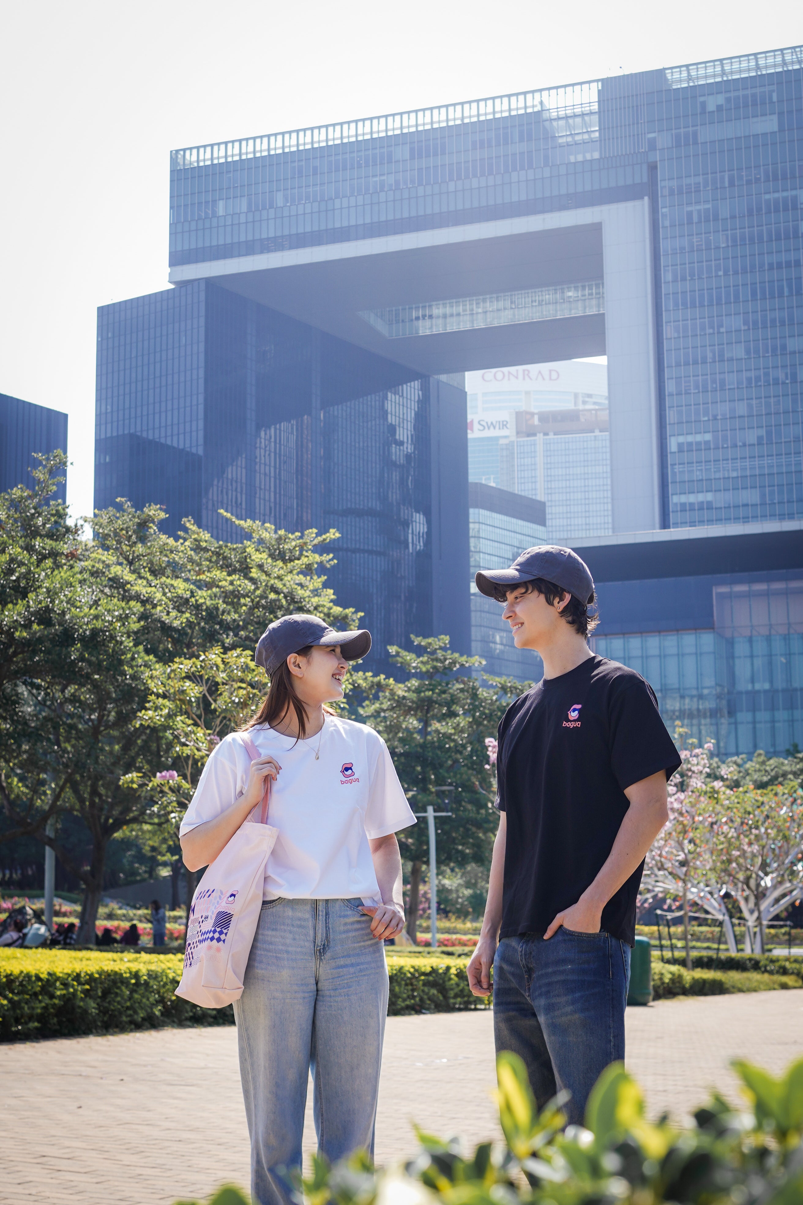 Two people standing outdoors in front of a modern building